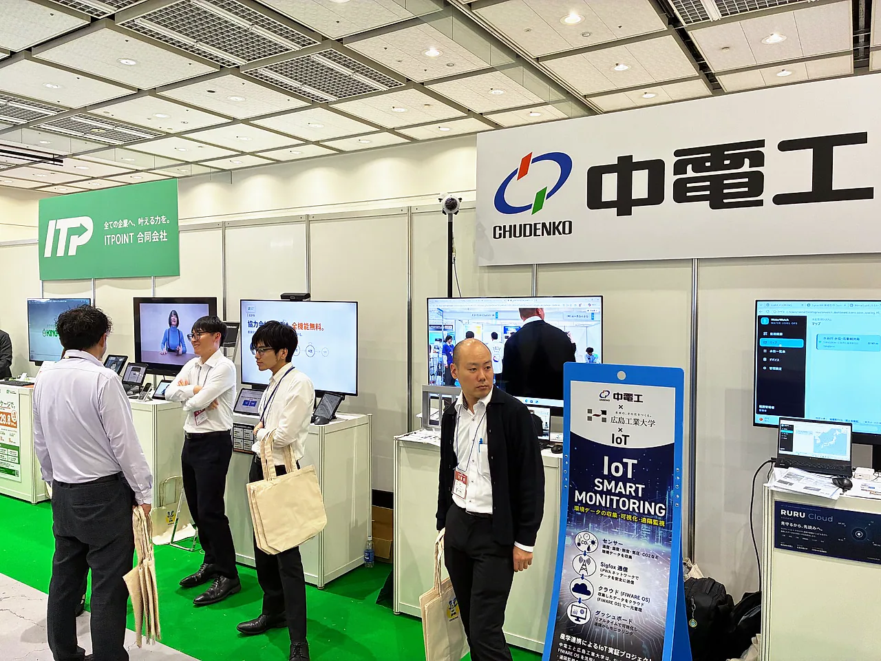 中電工様のブース。IoTスマートモニタリングのパネルとRURU Cloudの案内の前に、来場の方々が立っている